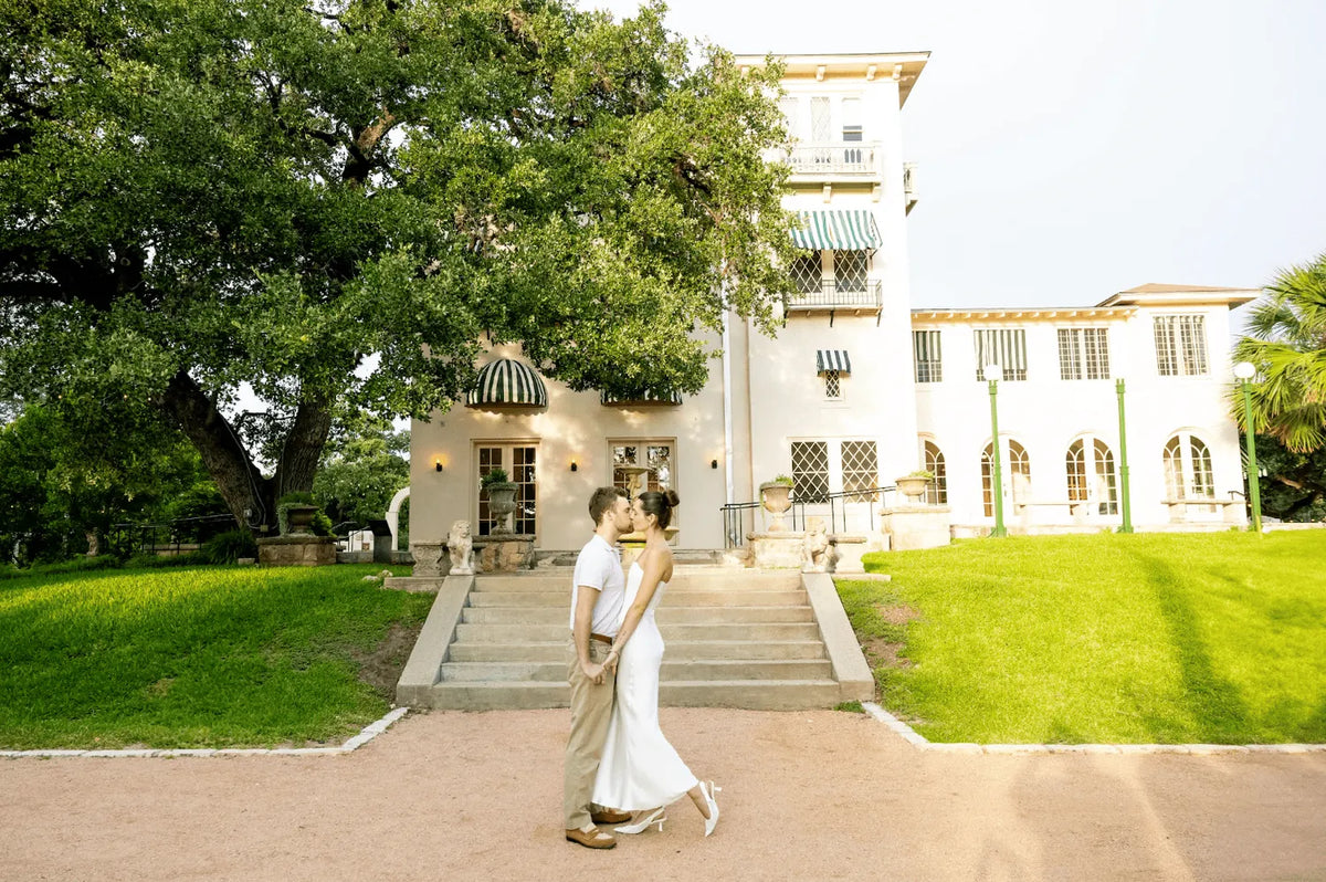 A couple in front of the Italian-style villa at Laguna Gloria.