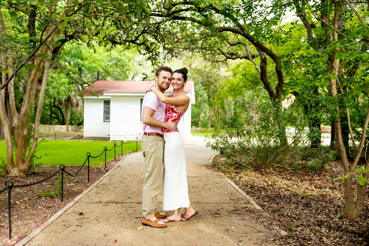 A couple embraces beside a garden path at Mayfield Park.