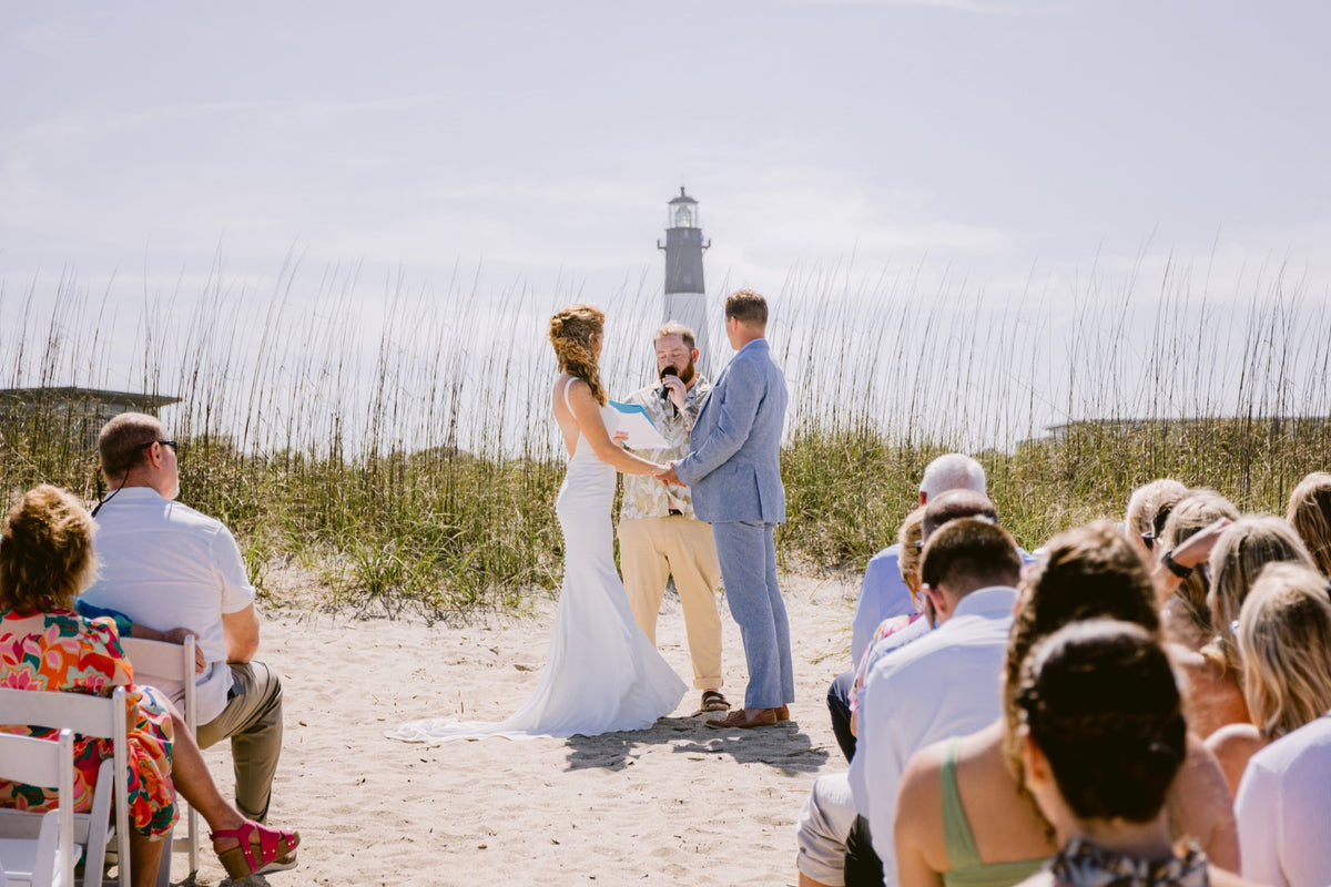 A beach ceremony with the lighthouse in the distance at Tybee Island. Josh Stewart Photography.