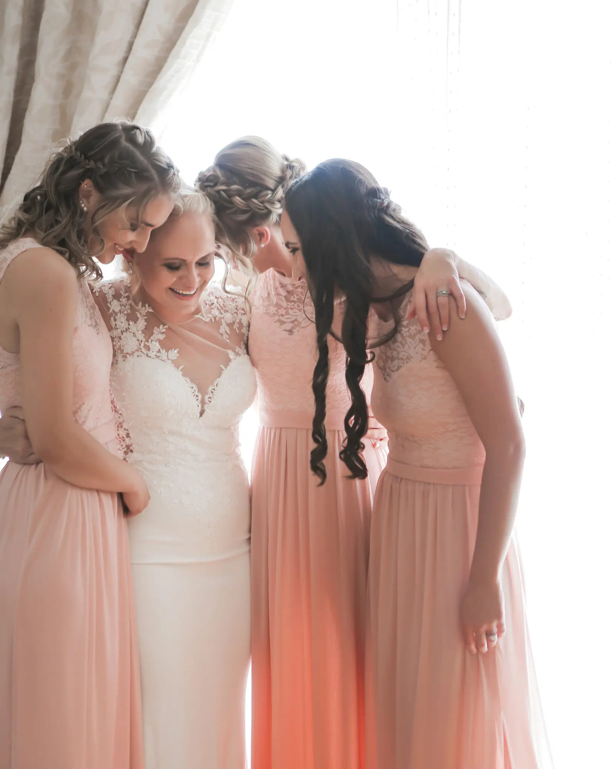A bride sharing a joyful moment with close friends before the ceremony.