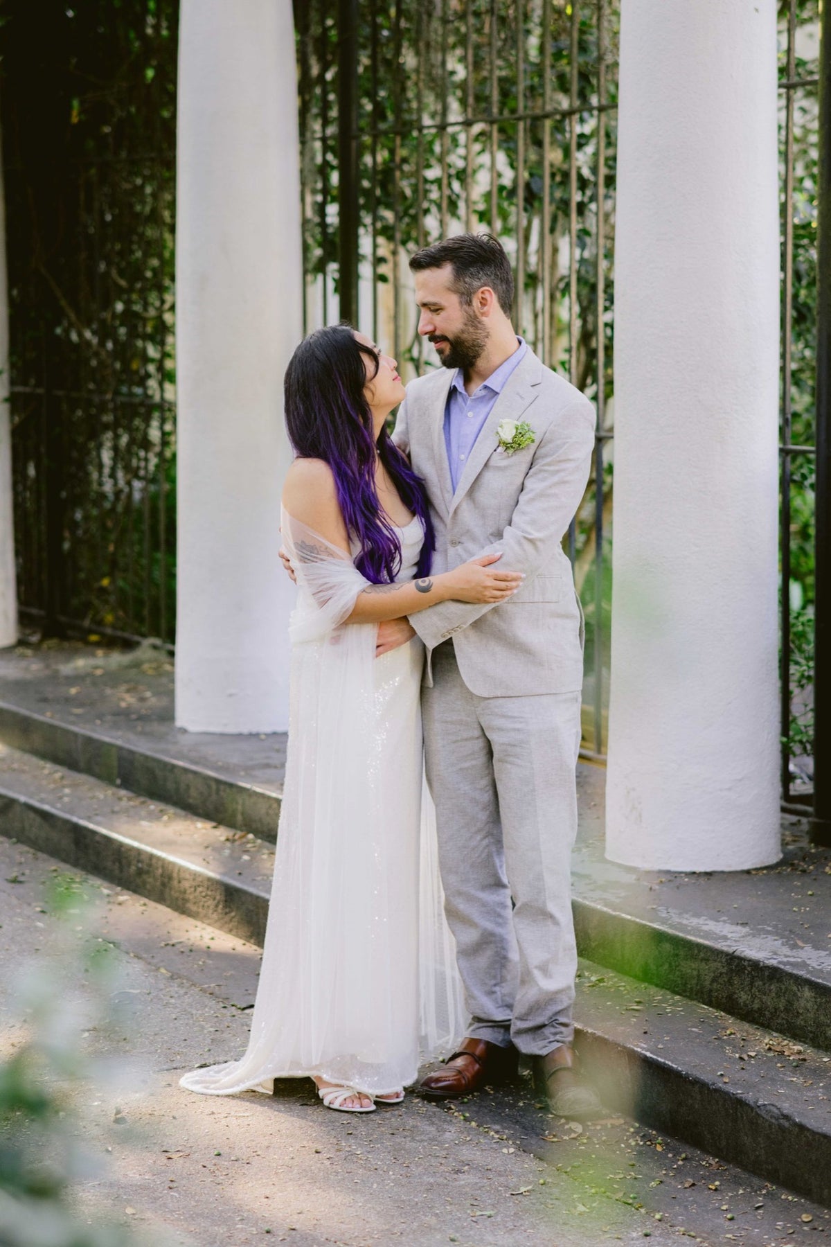 A couple beside the columns and iron gate at Forsyth Park's Fragrant Garden. Photography: Josh Stewart Photography.